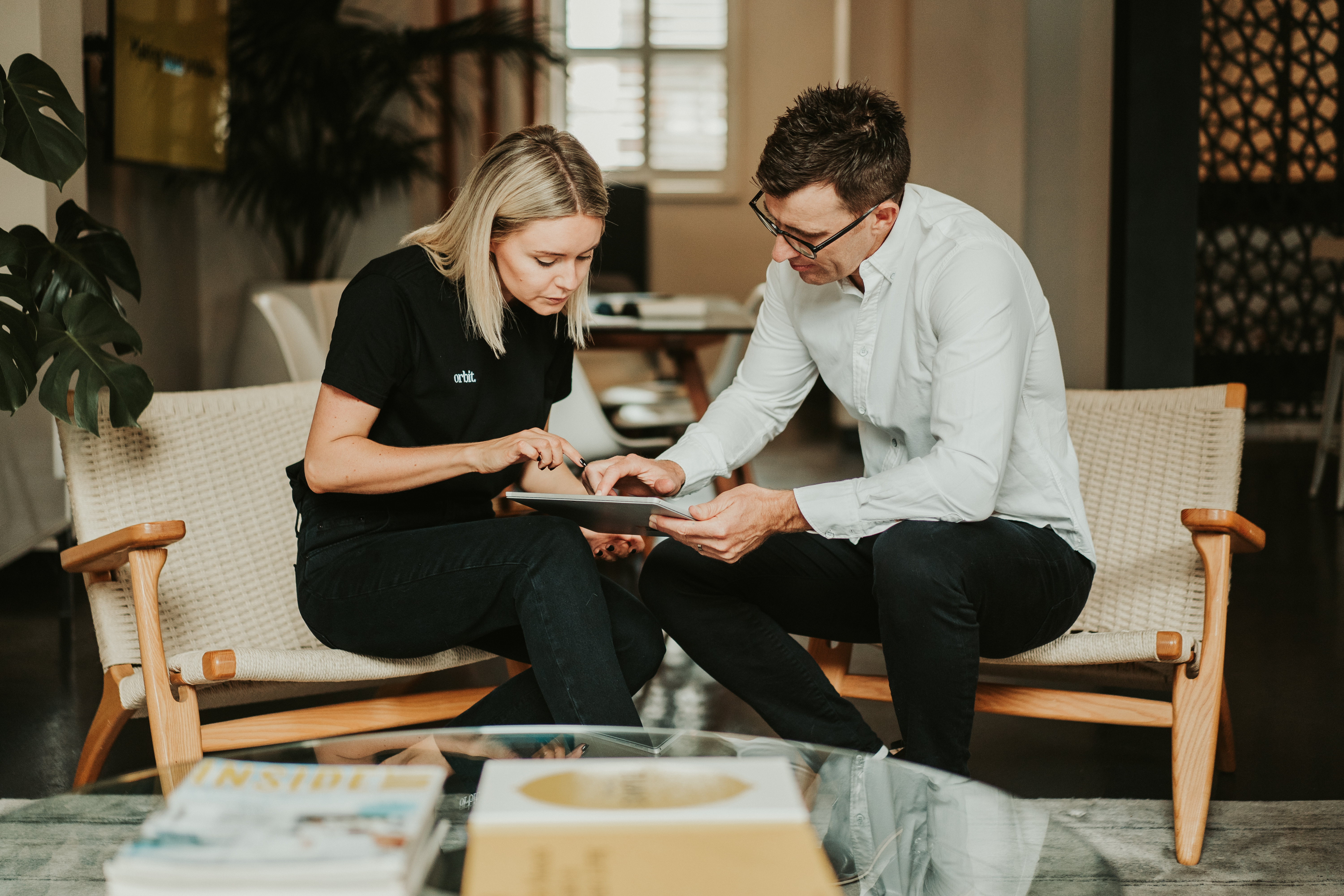 Founders, Greg And Kate Dennis, Seated In Meeting At Sydney Office Reviewing Xero Account On Ipad