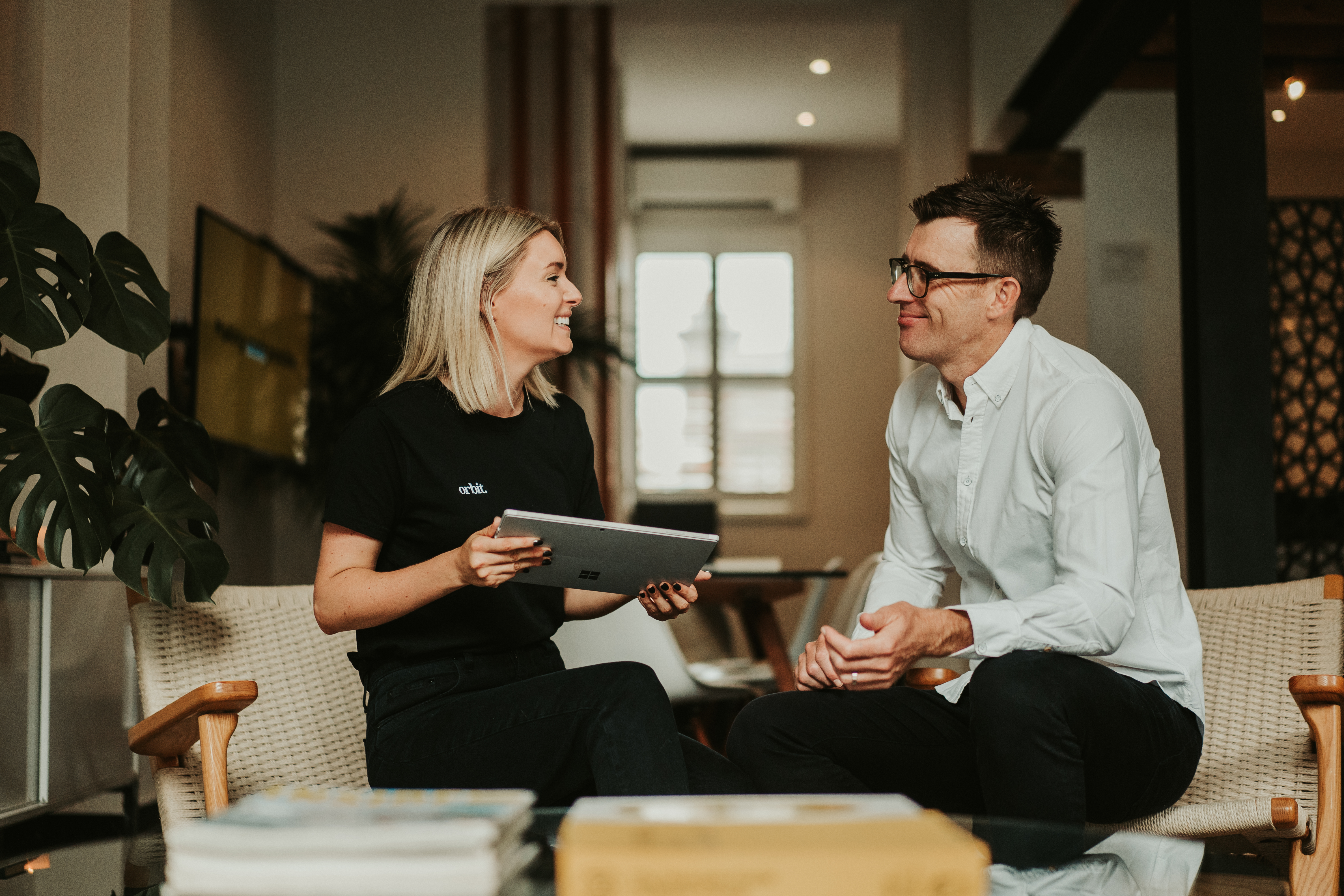 Orbits Founders Kate And Greg Conversing about Profit and Cash Randwick Office Over Ipad