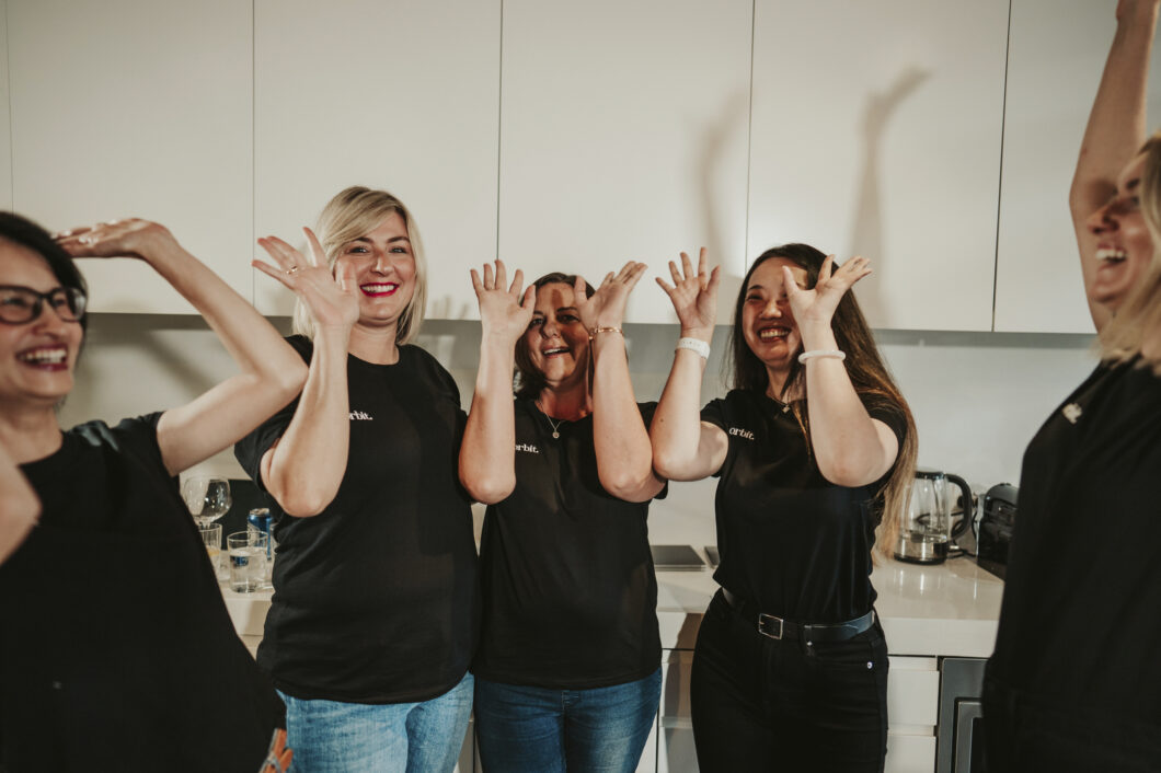 Orbit Team Throwing Their Hands In The Air In Randwick Office