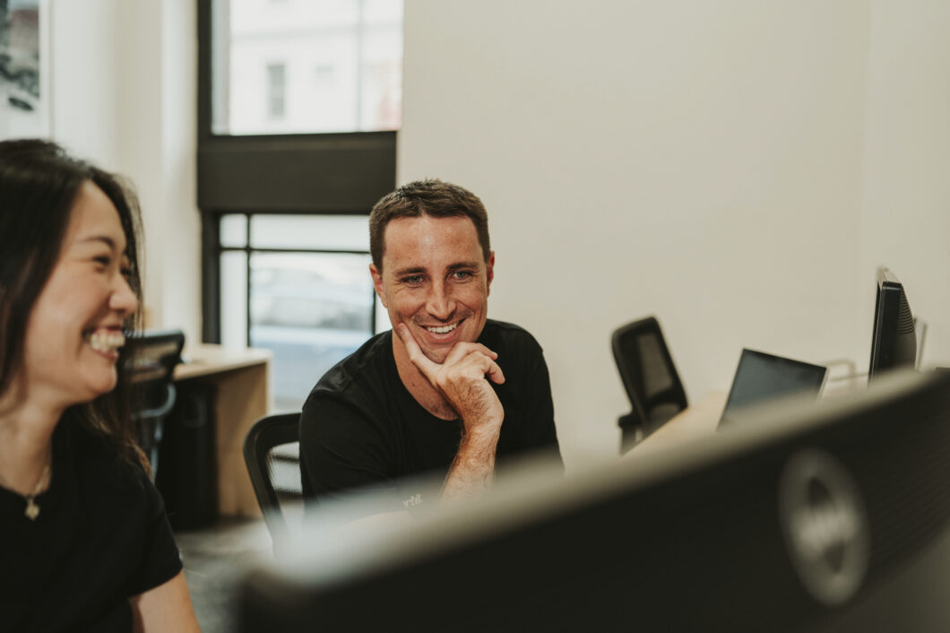 Orbit’s Senior Business Accountant, Alex Golding Smiling At His Desk At Randwick Office