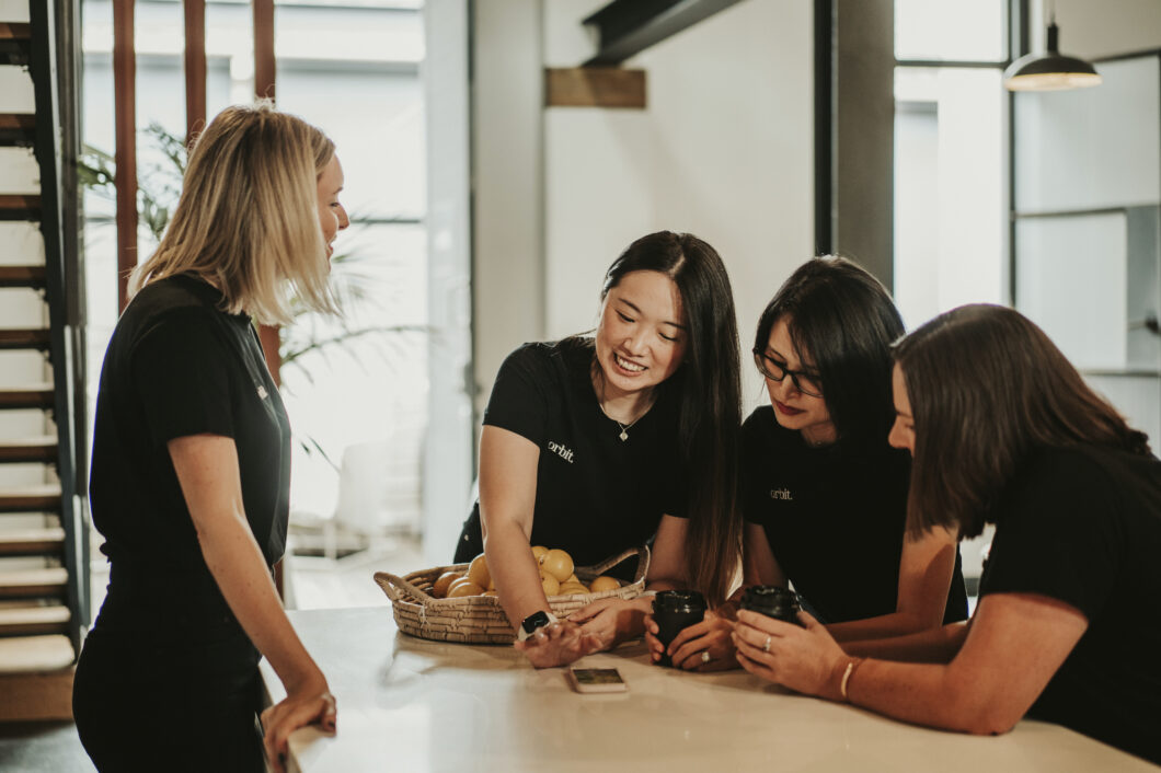 Orbit’s Team Of Sydney Business Accountants Looking At A Phone Application In Randwick Office